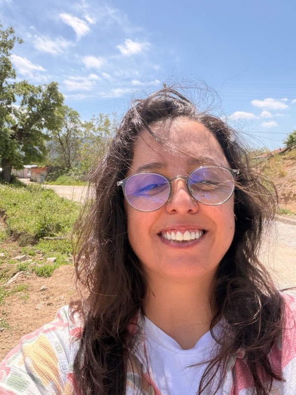 Burcu smiling on a sunny village road in Yukarıbey