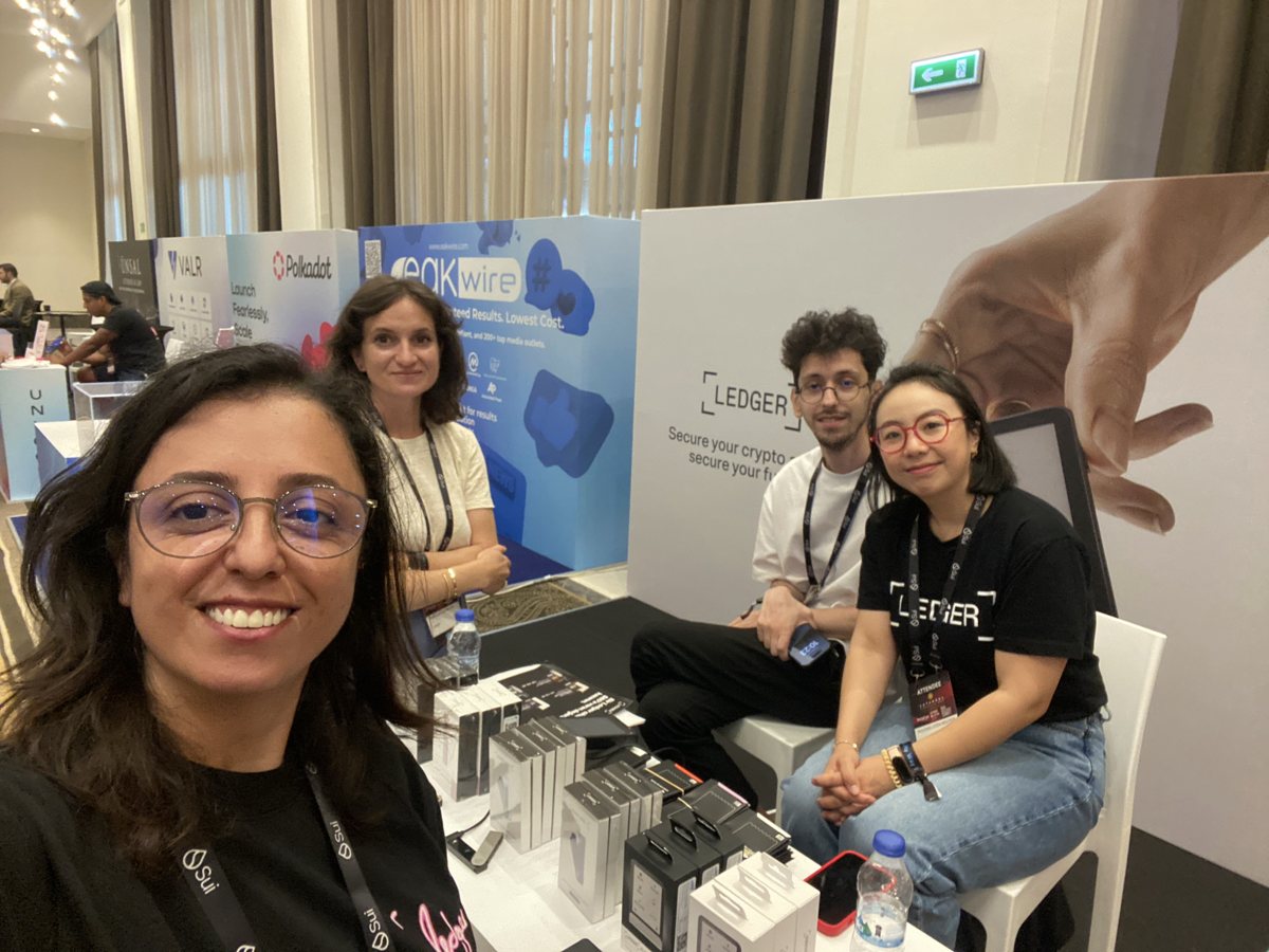 Burcu taking a selfie at the Ledger booth with three colleagues at Istanbul Blockchain Week 2025